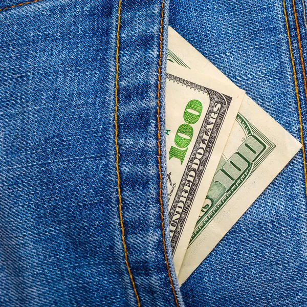 Closeup of one hundred US Dollar banknotes peeking out of blue j — Stock Photo, Image