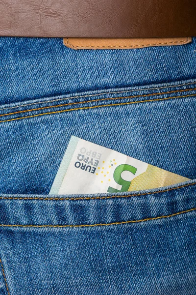 Primer plano de cinco billetes de euro asomándose por los pantalones vaqueros azules poc —  Fotos de Stock