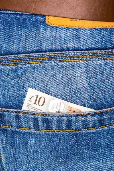 Closeup of ten pounds sterling banknote peeking out of blue jean — Stock Photo, Image