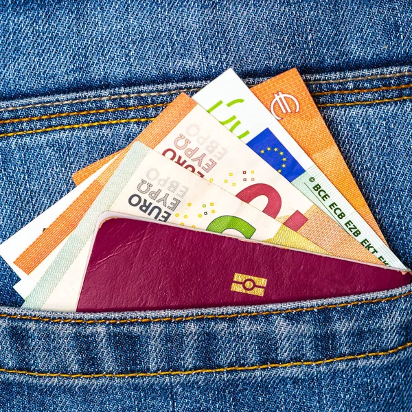 Primer plano de un puñado de billetes en euros y pasaporte de la UE espiando —  Fotos de Stock