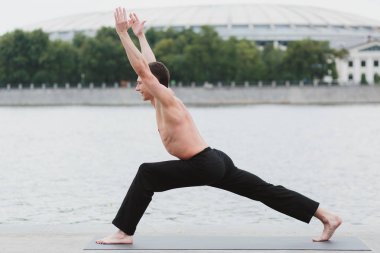 Yoga asanas şehrin Rıhtımlar üzerinde pratik bir genç adam