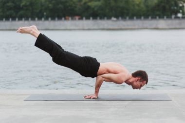 Yoga asanas şehrin Rıhtımlar üzerinde pratik bir genç adam