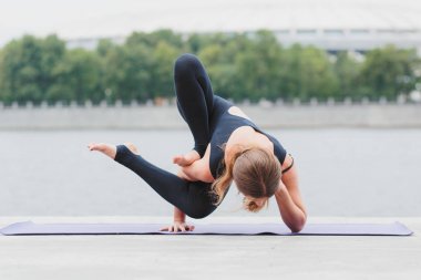 Yoga asanas şehrin waterfro üzerinde pratik bir genç kadın