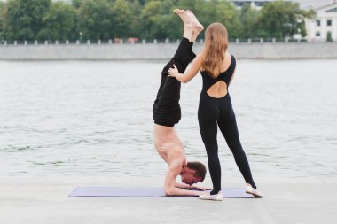 genç bir adam ve bir kadın yoga asanas şehrin inci üzerinde pratik