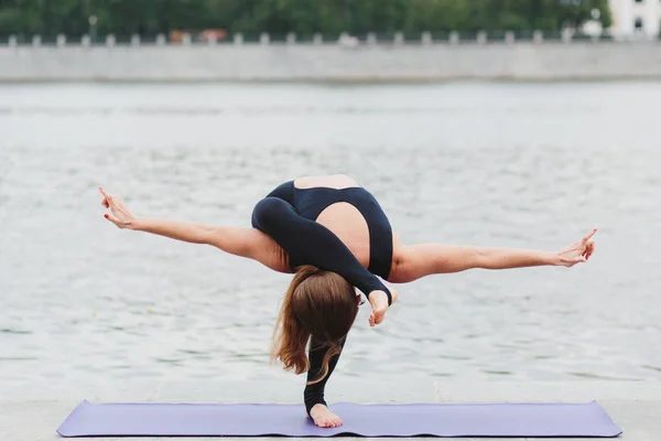 Yoga asanas şehrin waterfro üzerinde pratik bir genç kadın