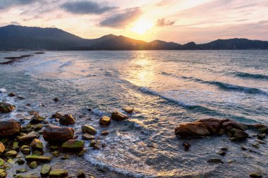 Güzel deniz manzarası. Dalgalar bir tropikal deniz kıyısında günbatımı