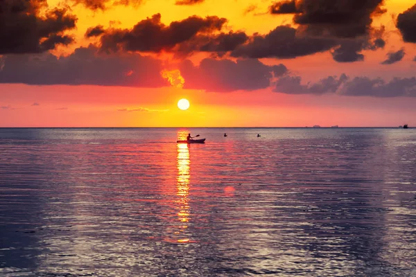 Silhouette of a man on a kayak in the sea against a beautiful br — Stock Photo, Image