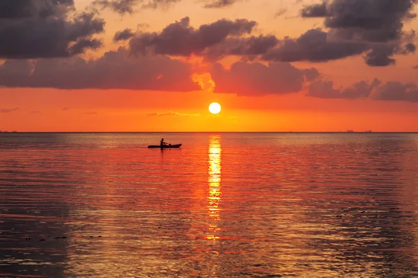 Silhouette of a man on a kayak in the sea against a beautiful br — Stock Photo, Image