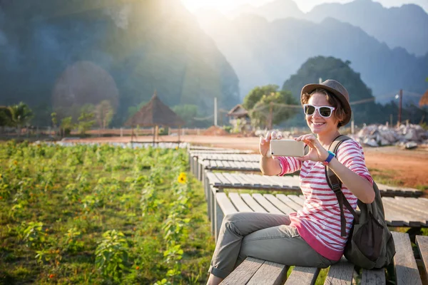 Όμορφη νεαρή γυναίκα παίρνει ο ταξιδιώτης σε ένα κινητό τηλέφωνο εδάφη — Φωτογραφία Αρχείου