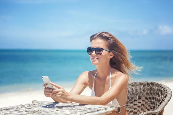 Junge schöne Frau mit Handy am Ufer der Trop — Stockfoto