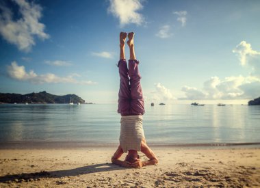 Şafakta, ayakta o kumsalda yoga yaparken genç çekici adam