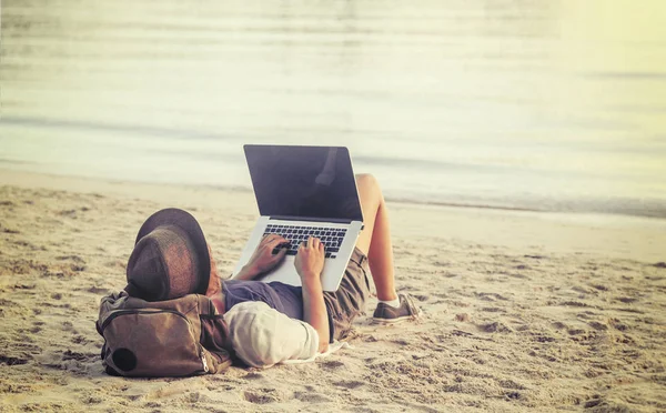 Молодая женщина использует ноутбук на пляже. Афера с фрилансером — стоковое фото