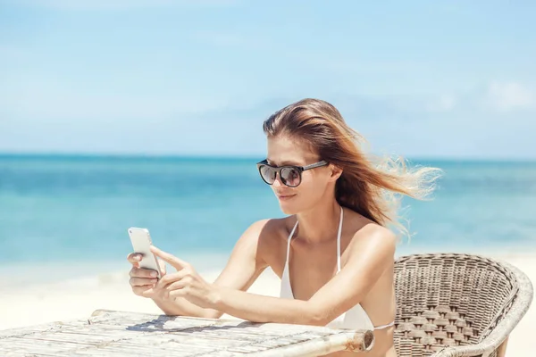 Junge schöne Frau mit Handy am Ufer der Trop — Stockfoto