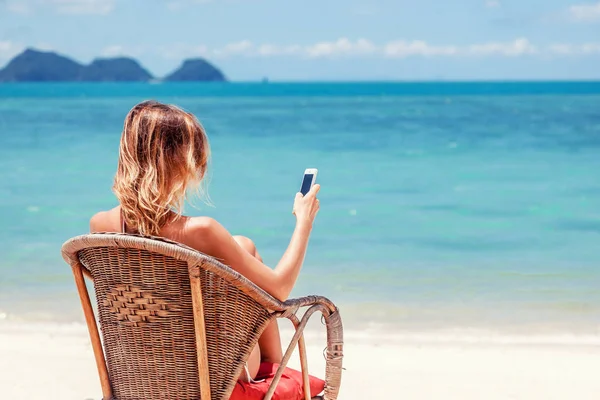 Cep telefonu trop kıyısında olan güzel kadın — Stok fotoğraf