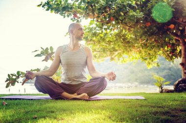 Doğada yoga yaparken genç bir adam. Sağlıklı yaşam, meditasyon,