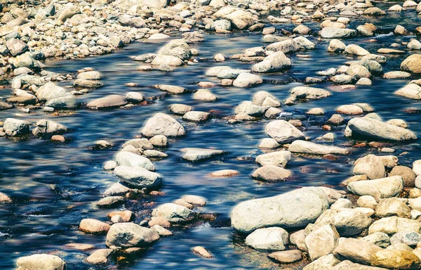 L'acqua scorre sulle rocce, sullo sfondo naturale e sulla consistenza — Foto Stock