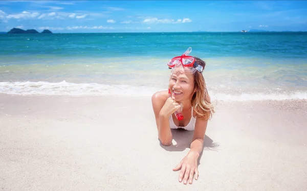 Krásná mladá žena leží na tropické pláži s snorkellin — Stock fotografie