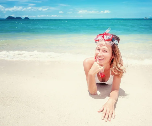 Beautiful young woman lies on a tropical beach with a snorkellin — Stock Photo, Image