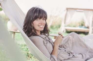 bir hamakta açık portr koyu saçlı güzel genç kadın