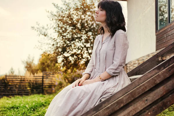 Beautiful young woman with dark hair sitting on the steps near t — Stock Photo, Image