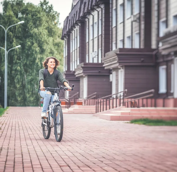 Güzel genç kız öğrenci bir kazak ve bir bicyc kot