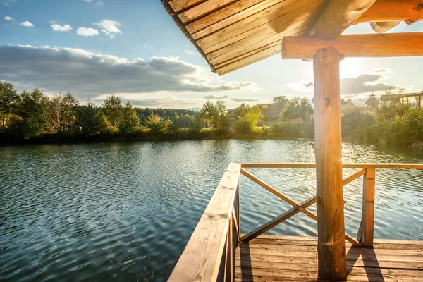 Su Gölü, günbatımında bir teras ile ahşap ev,