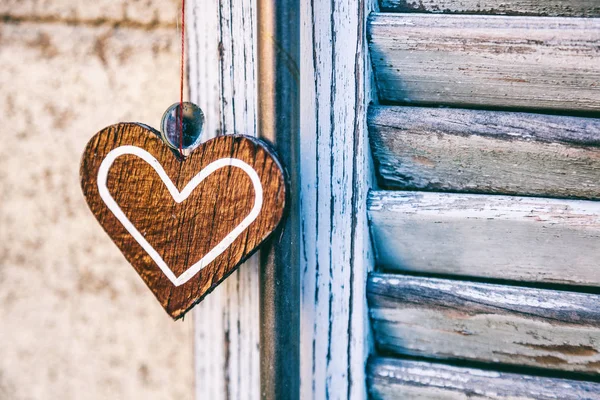 Dekoratives Holzherz auf dem Hintergrund eines Fensterladens, abs — Stockfoto