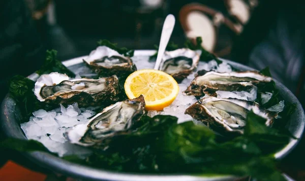 大皿にレモンのスライスと新鮮なおいしい牡蠣 — ストック写真