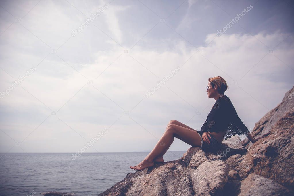 beautiful stylish young woman with long legs sitting on large st
