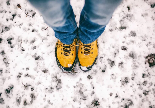 Feet in yellow trekking boots on snow, a trip in winter, a pictu — Stock Photo, Image