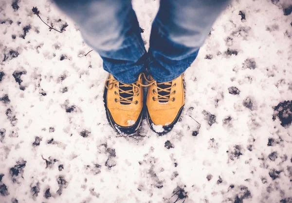 Feet in yellow trekking boots on snow, a trip in winter, a pictu — Stock Photo, Image