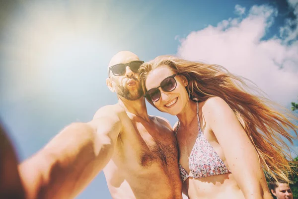 Schönes junges lustiges Paar macht Selfie am Ufer des tr — Stockfoto