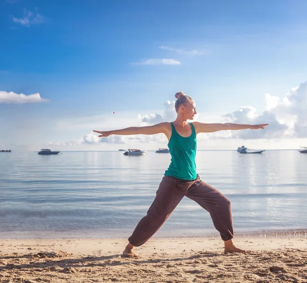 Belle jeune femme blonde faisant du yoga sur le rivage d'une tropica — Photo