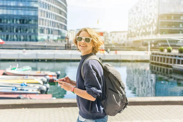 Happy young stylish woman with mobile phone in hands on city bac — Stock Photo, Image