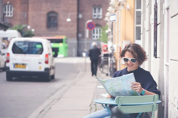 Jeune belle voyageuse assise dans un café dans la rue et l — Photo