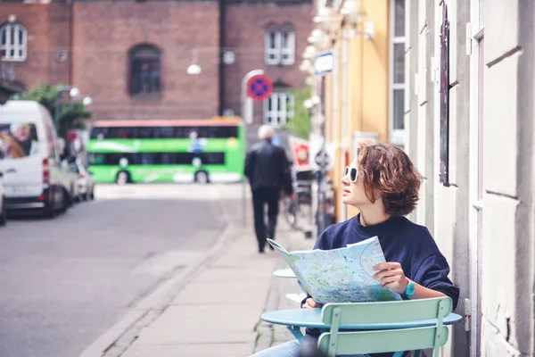 Jeune belle voyageuse assise dans un café dans la rue et l — Photo