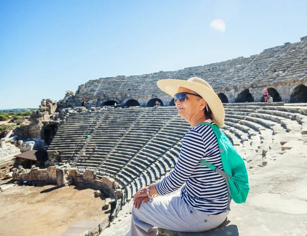 Ώριμη όμορφη γυναίκα ταξιδιώτη, κάθεται στα σκαλιά του το amphit — Φωτογραφία Αρχείου