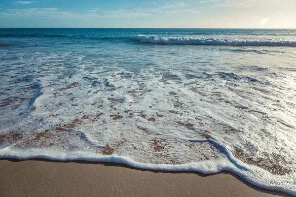 Minimalistische achtergrond, blauwe oceaan, zanderige strand, schittering van t — Stockfoto