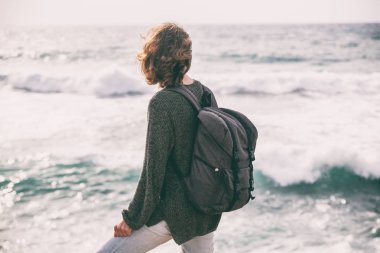 Bir kızla bir sırt çantası ile fırtınalı s sırtında duruyor