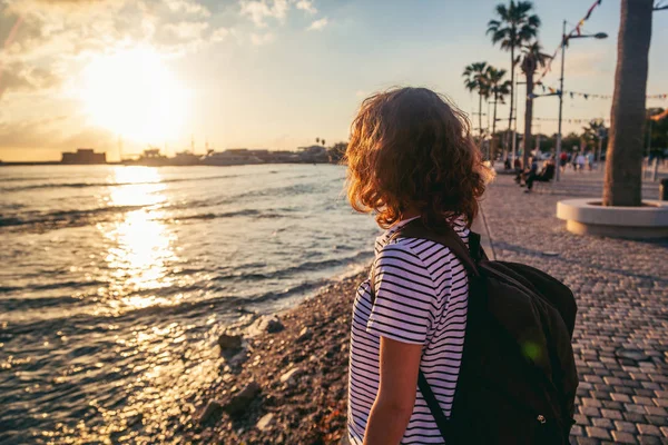 Молода красива дівчина з рюкзаком йде уздовж морського сміття — стокове фото