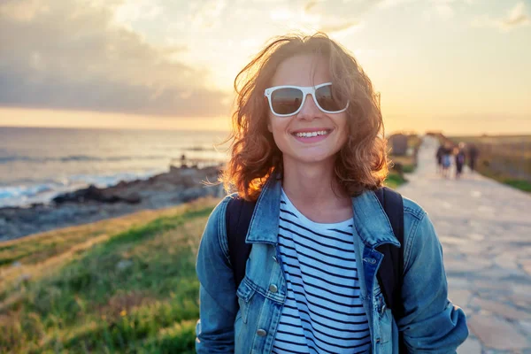 Schöne glückliche junge Frau, die entlang der Uferpromenade bei — Stockfoto