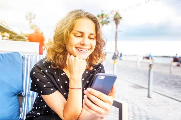 Jovem bela mulher menina sentada em um café de rua sorrindo com — Fotografia de Stock