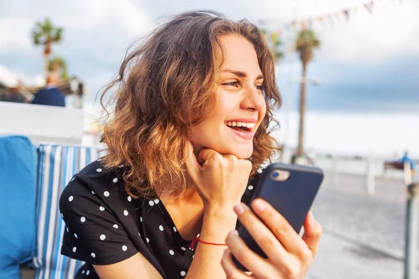 Jovem bela mulher menina sentada em um café de rua sorrindo com — Fotografia de Stock