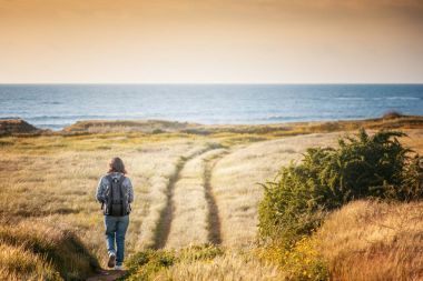 Gün batımı, genç şık kadın Gezgin, güzel deniz manzarası yürür