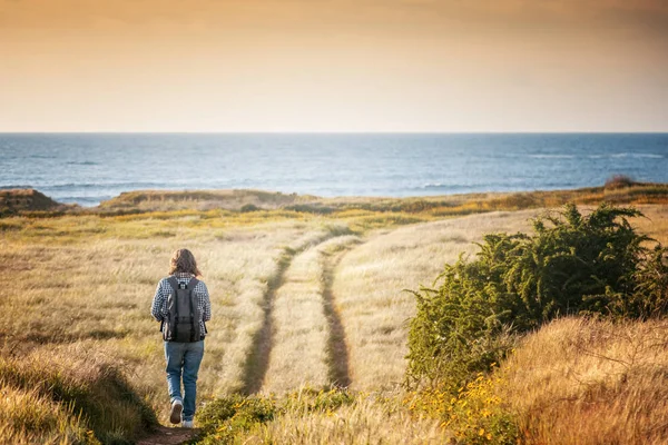 Gün batımı, genç şık kadın Gezgin, güzel deniz manzarası yürür