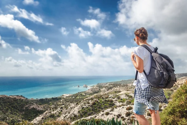 A young traveler woman with a backpack on a stunning landscape b — Stock Photo, Image