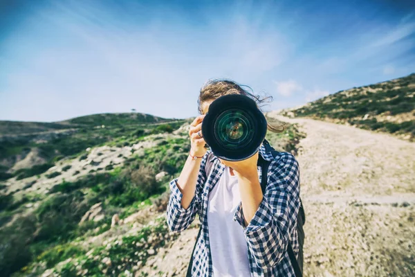 Девушка путешественник с камерой в руке, против красивого лета — стоковое фото