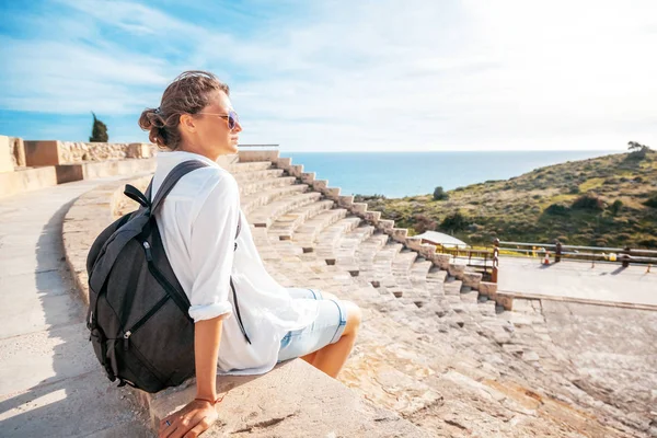 Μια νεαρή όμορφη γυναίκα ταξιδιώτης κάθεται στα σκαλιά του μια amphith — Φωτογραφία Αρχείου