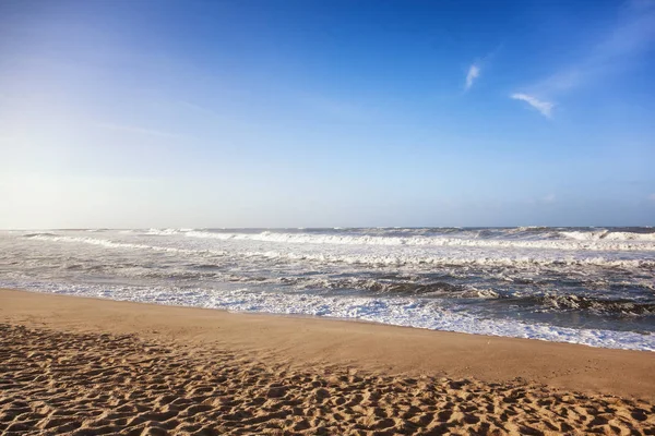 Bela costa oceânica arenosa, ondas e céu azul — Fotografia de Stock