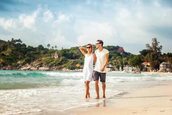 Bella giovane coppia a piedi sulla riva del mare tropicale — Foto Stock